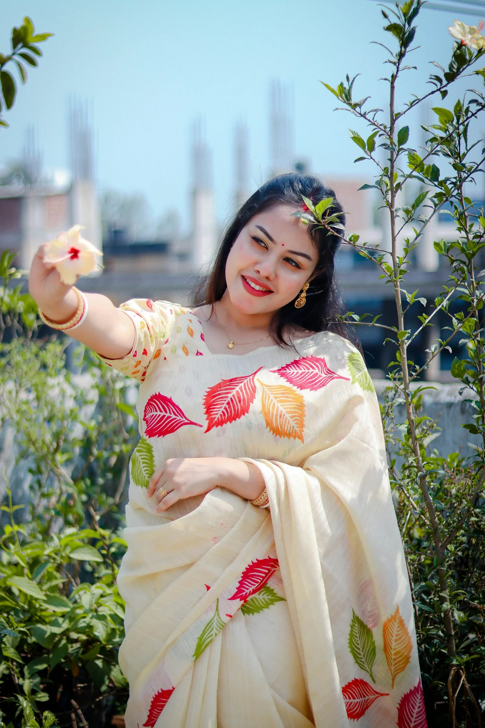 Woman in saree posing with a flower