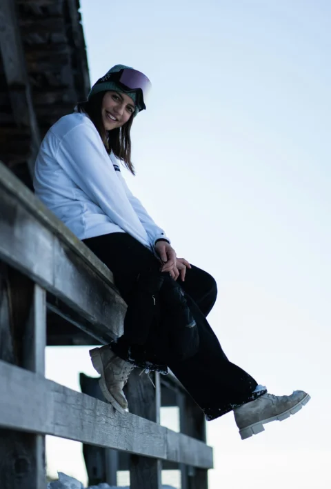 a woman is sitting on a wooden bench