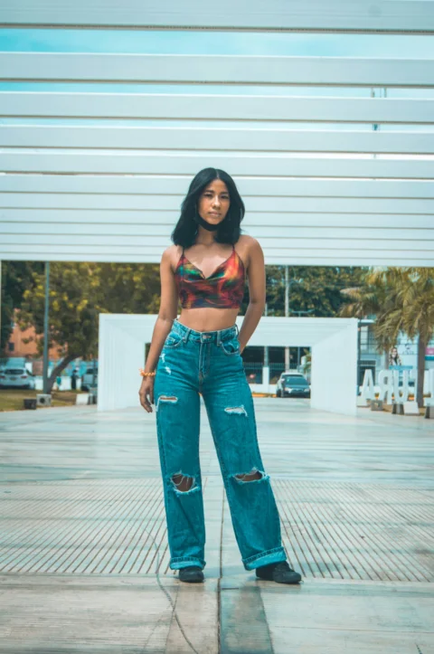 a woman in a crop top and jeans posing for a picture