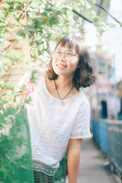 黒縁メガネをかけた白いTシャツ姿の女性のピントの浅い写真