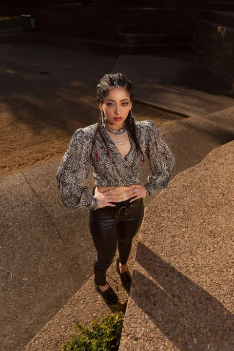 a woman standing on a sidewalk with her hands on her hips