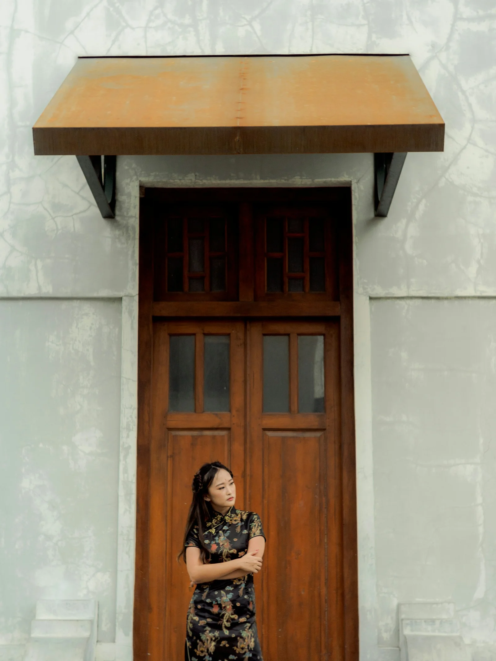 a woman standing in front of a wooden door