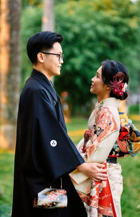 Japanese couple in kimonos looking at each other outdoors