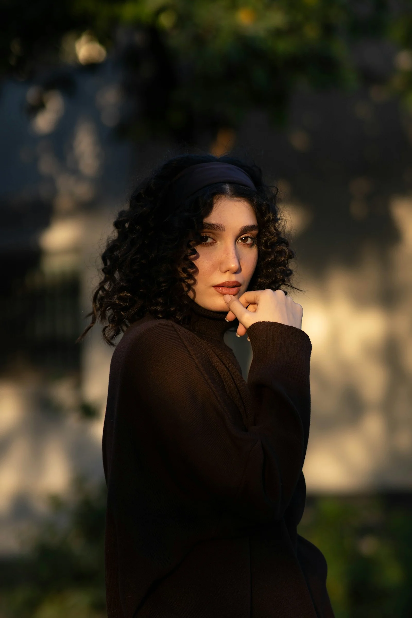 Young woman with curly hair wearing a dark turtleneck