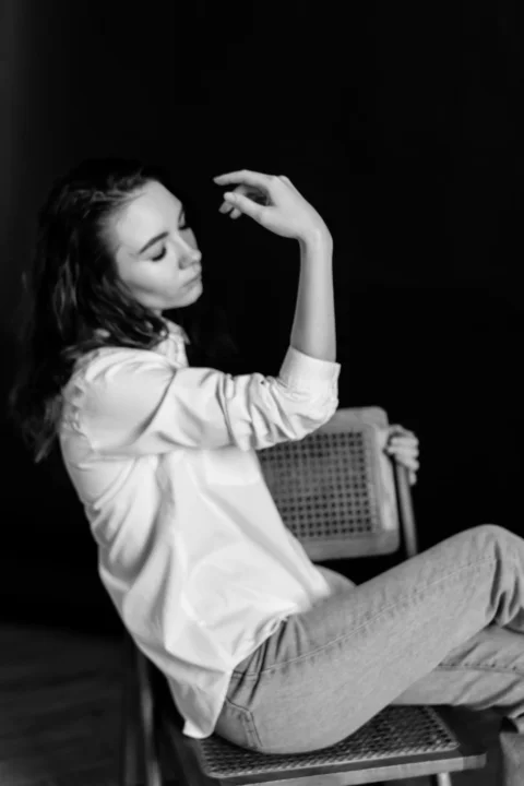 a black and white photo of a woman sitting on a chair