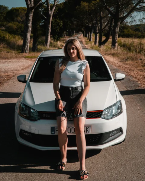 a woman sitting on the hood of a white car