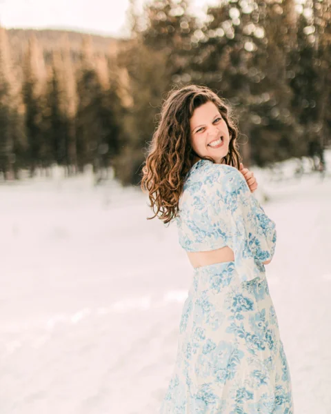woman in white and red floral dress standing on snow covered ground during daytime