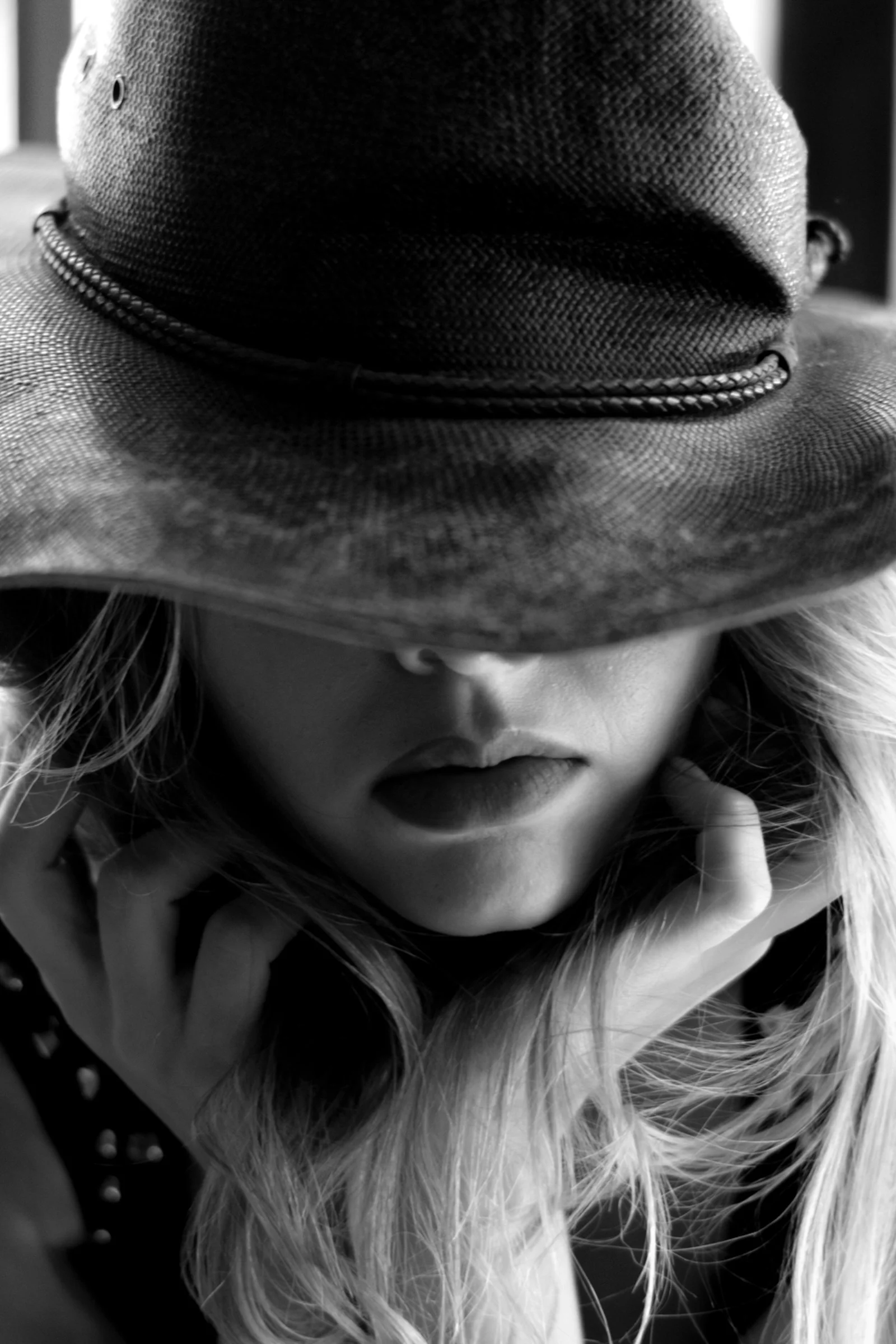 Woman in a hat hides her face in thought