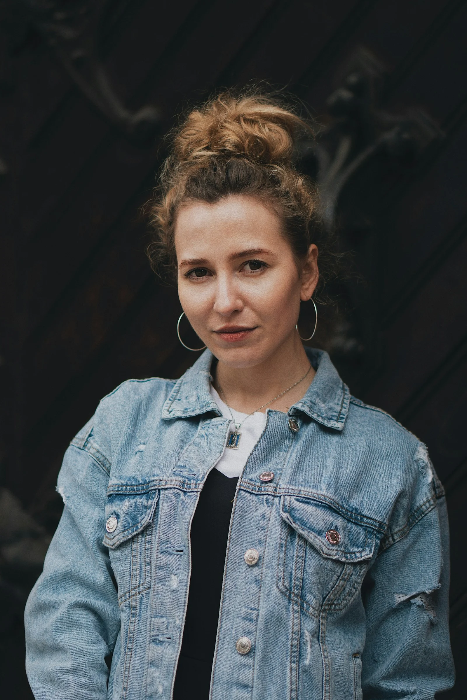 standing woman wearing blue denim jacket