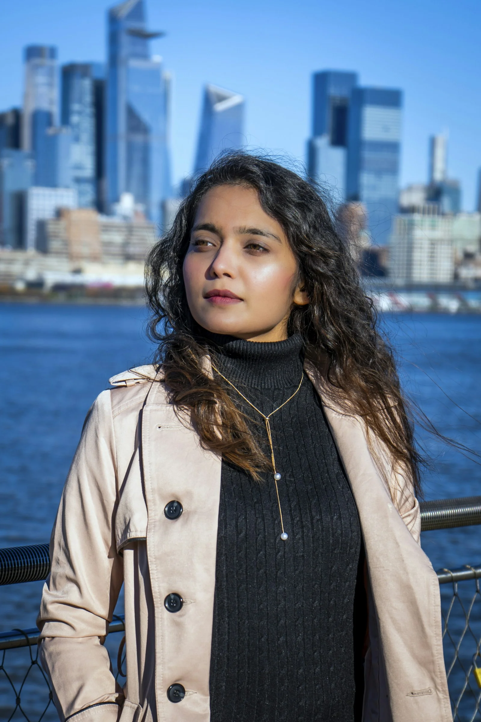 a woman standing in front of a body of water