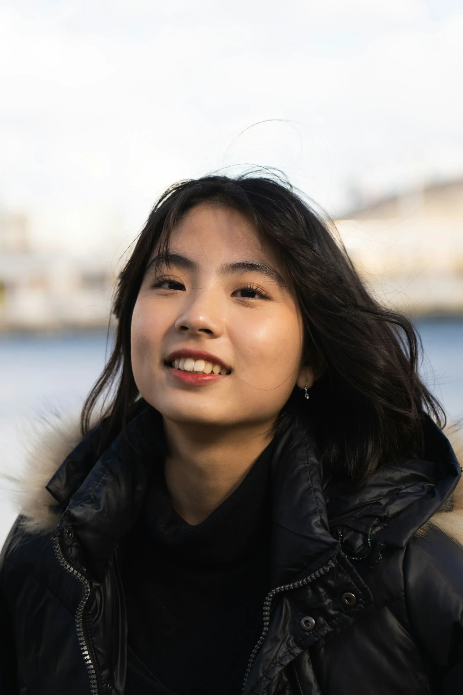 一名穿黑色夾克的女人對著鏡頭微笑
