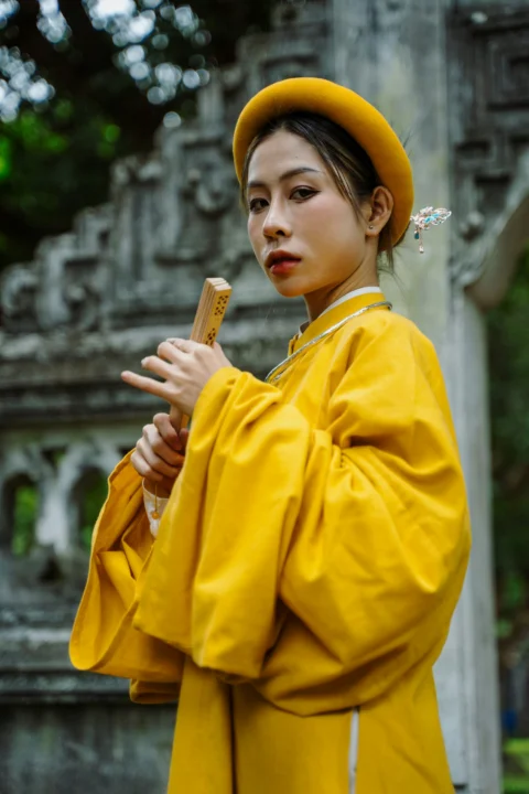 穿黃色服裝的女人手持一根棍子