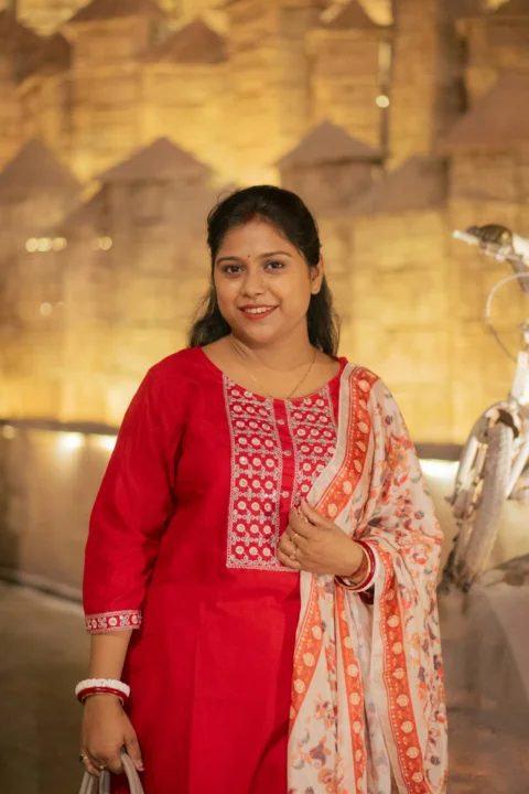A woman in a red kurta with a floral scarf