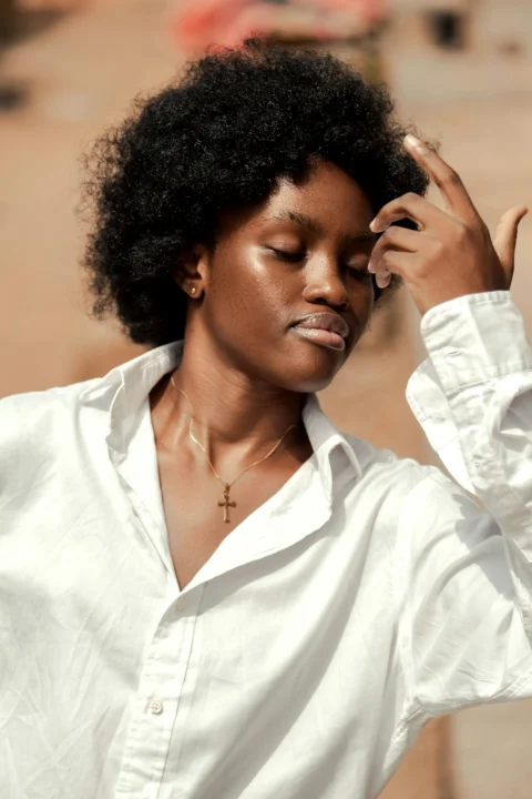 a woman wearing a white shirt and a cross necklace
