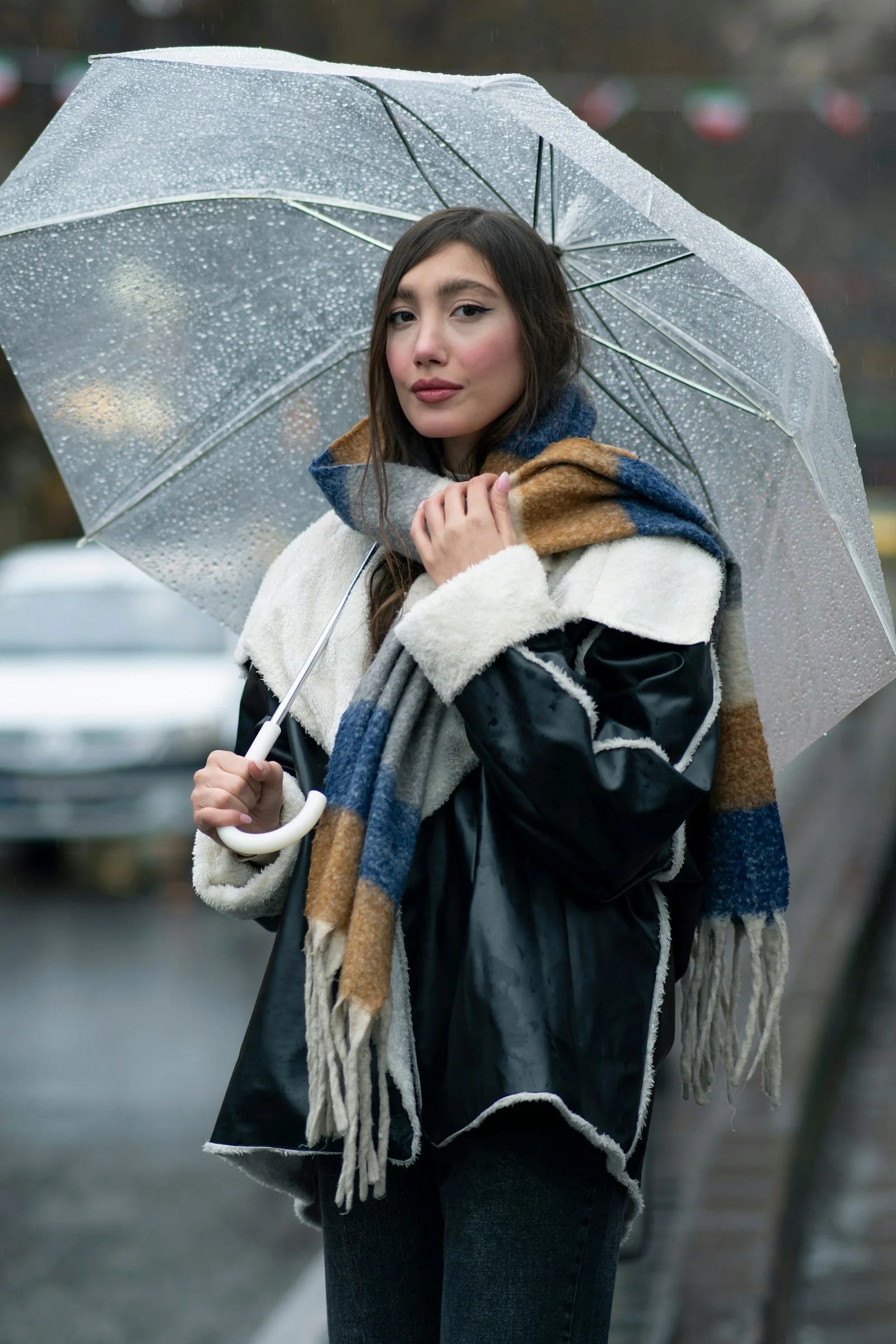 A woman walking down a street holding an umbrella