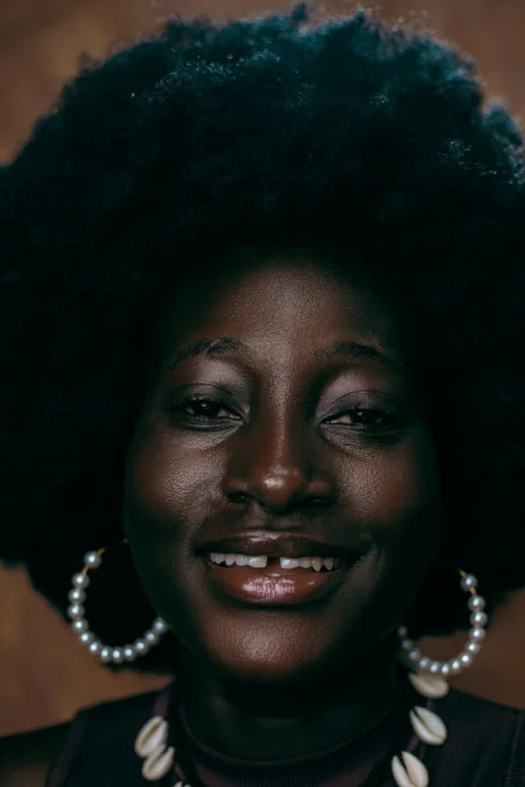 a woman with an afro and pearls on her necklace