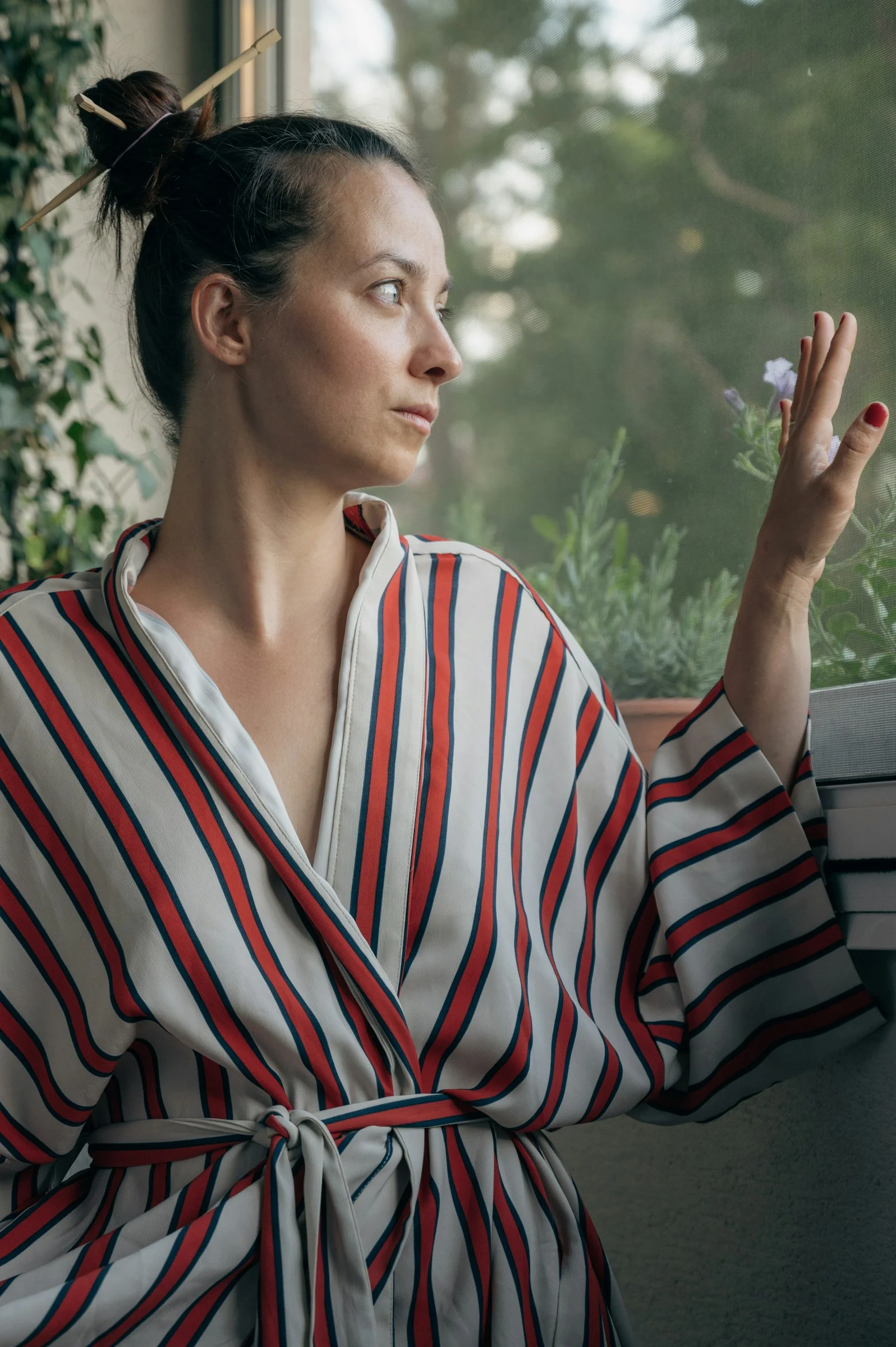 一名身穿长袍的女性望向窗外