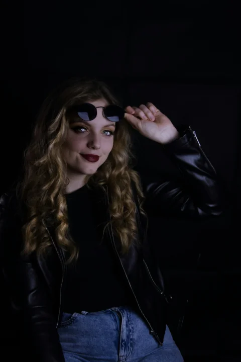 a woman in a leather jacket and sunglasses