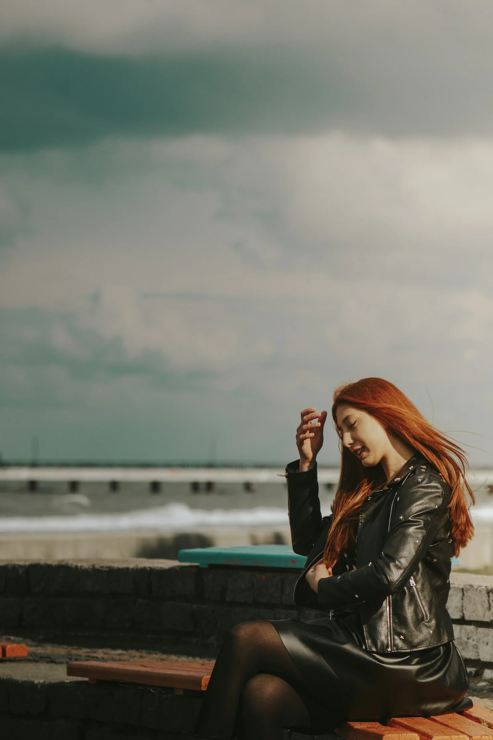 a woman with red hair sitting on a bench