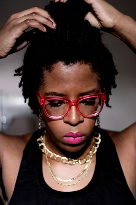 woman in black tank top wearing red framed eyeglasses