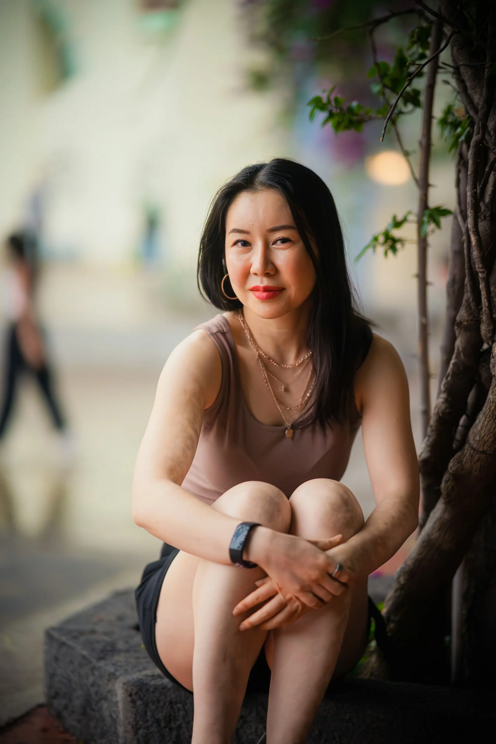 一位女人坐在树旁的长椅上