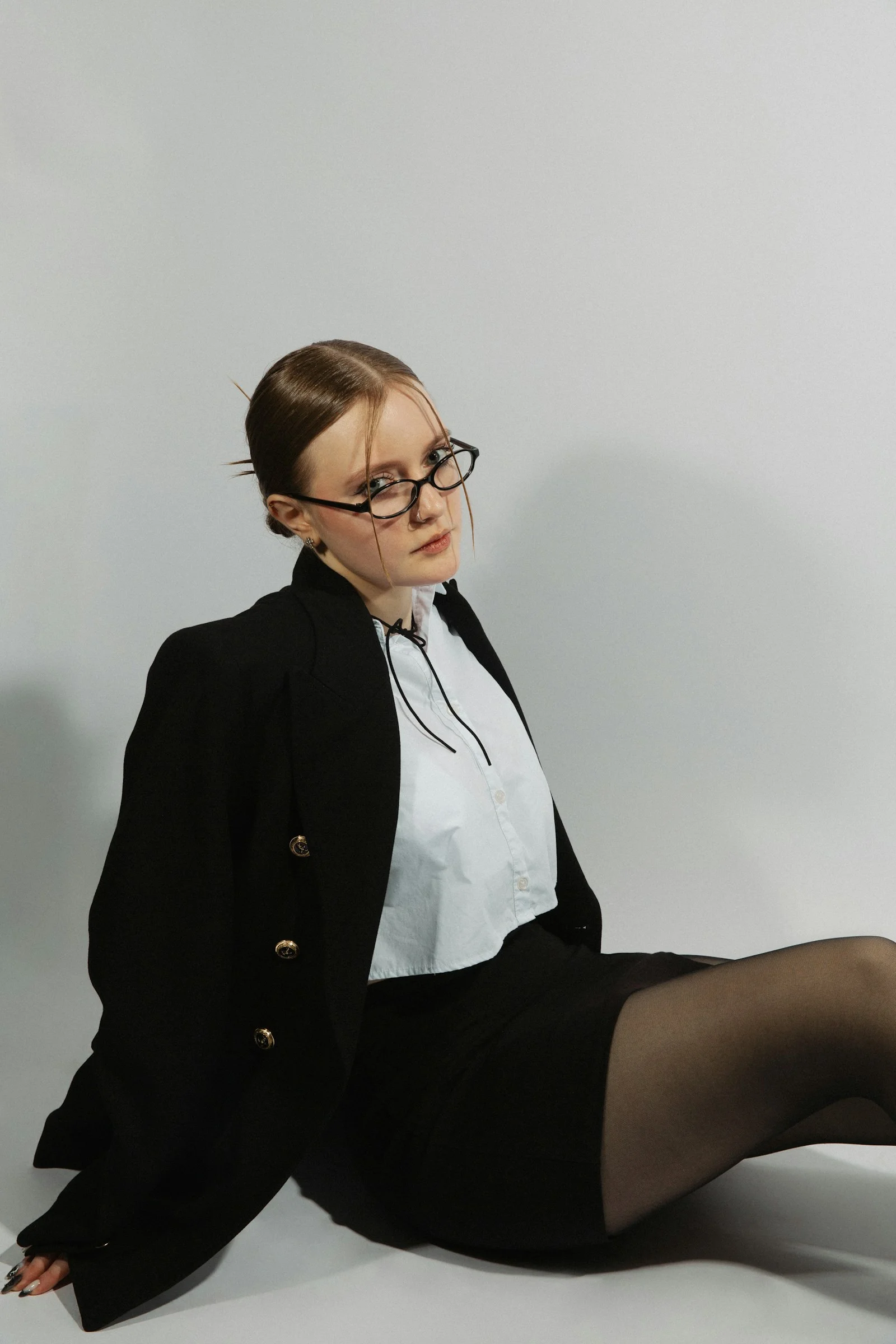 Woman in a suit poses, looking at the camera
