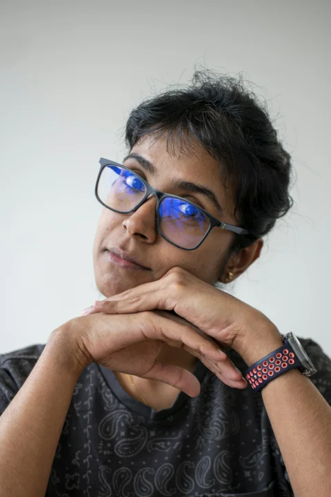 Woman with glasses looking thoughtful and content