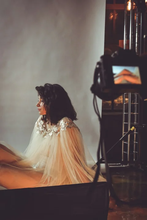 sitting woman wearing white lace dress with white background