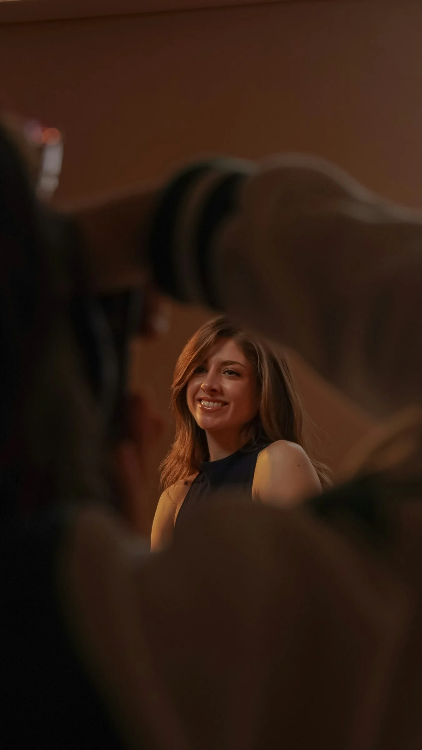 Smiling woman with long hair being photographed