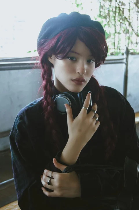 a woman with red hair is holding a hair dryer
