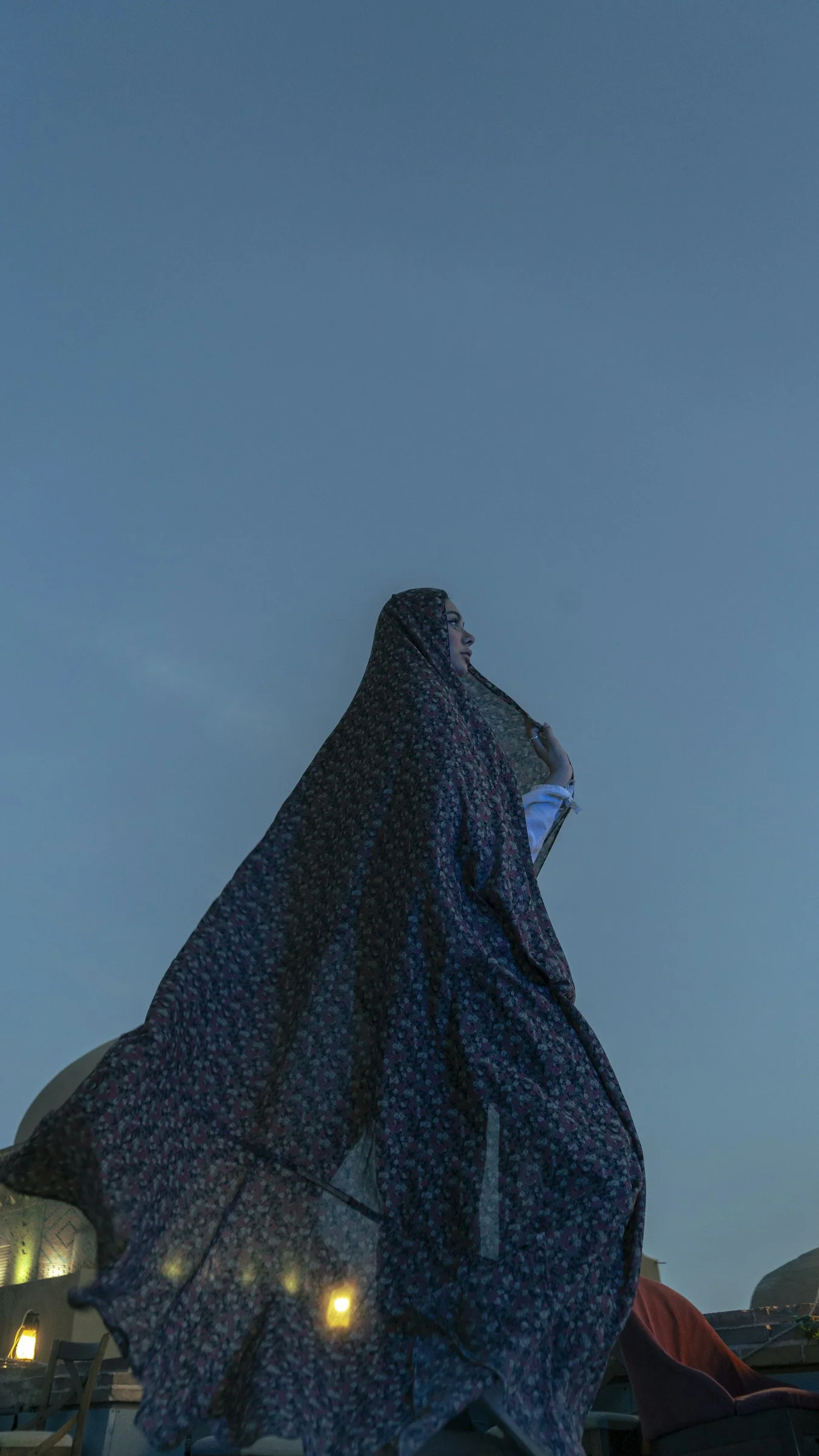 空を背景にベールをまとった女性