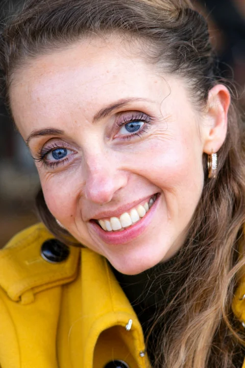 smiling woman in yellow jacket