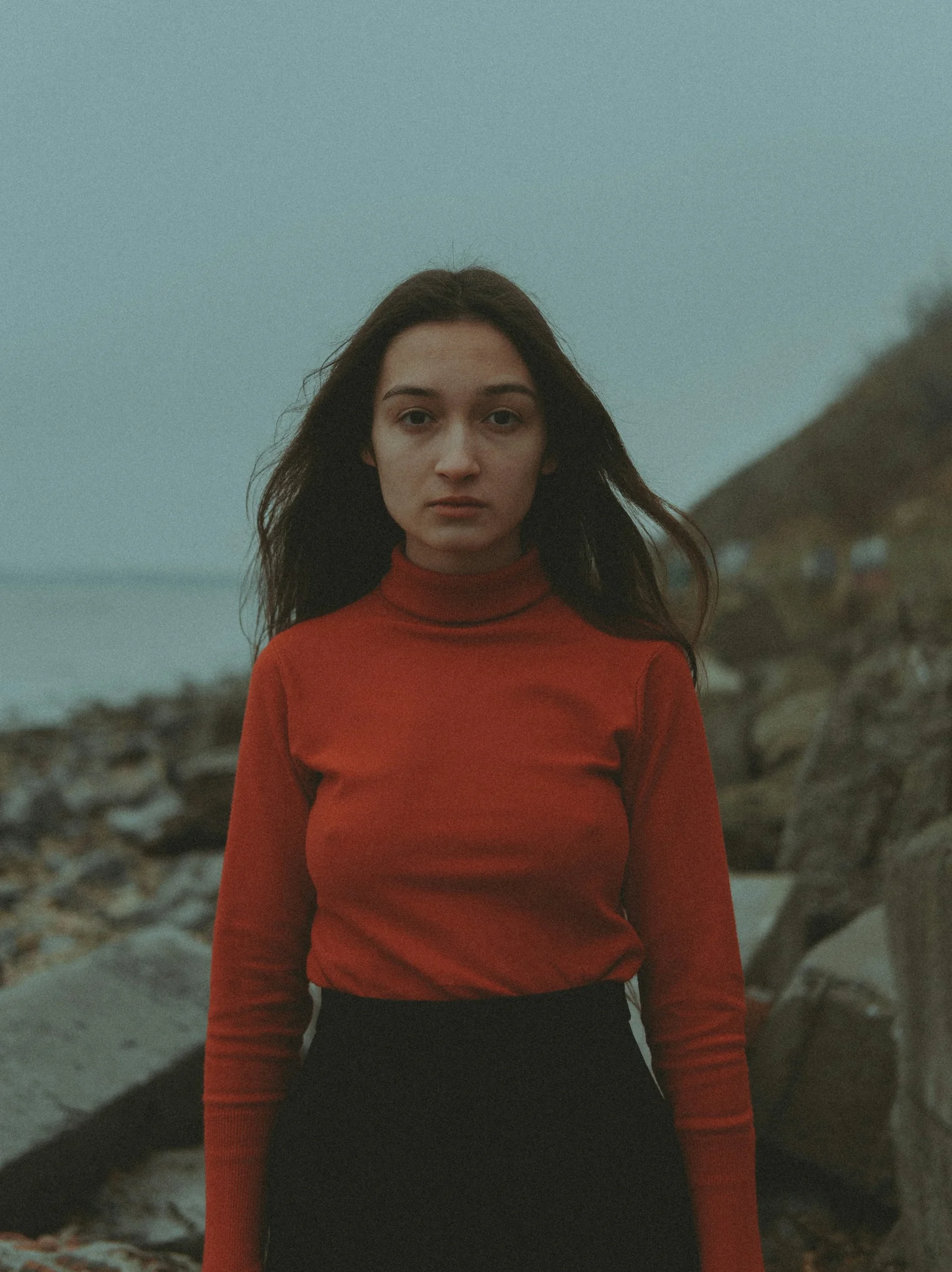 a woman in a red shirt and black skirt