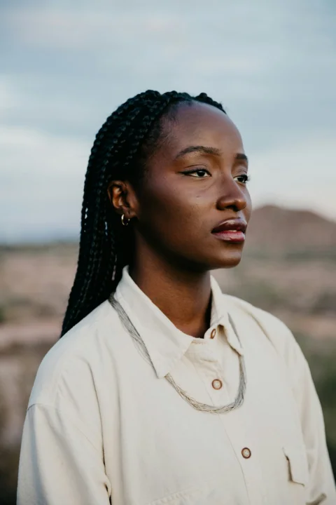 A young woman with braided hair in a desert