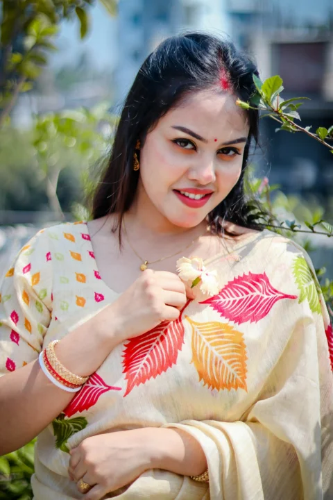A beautiful woman smiles, wearing a saree
