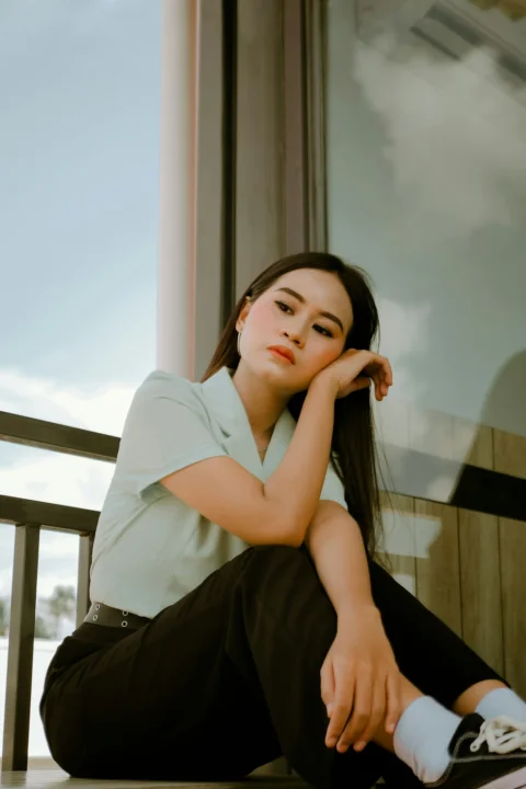 woman in white shirt sitting on brown wooden chair