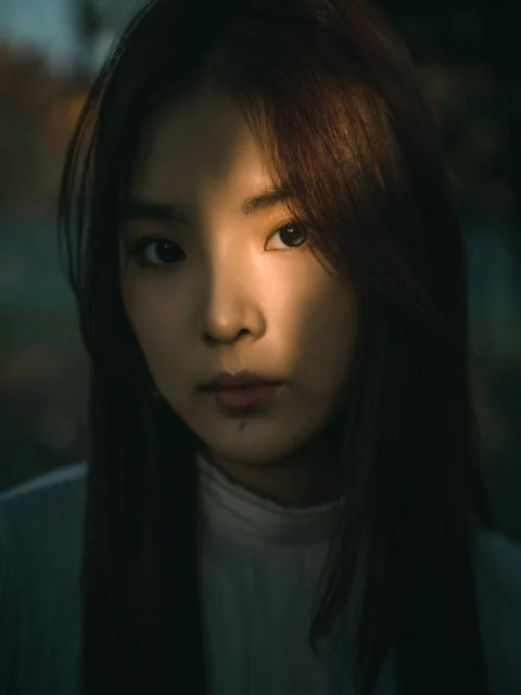 一位脸上映着阴影的年轻女子