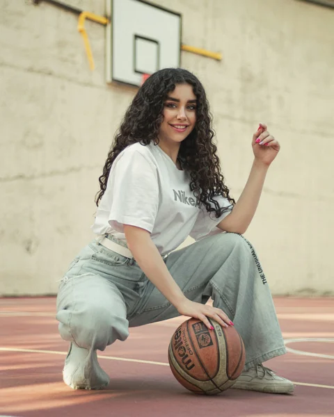 白いTシャツと青いデニムジーンズを穿いた女性が床に座っている