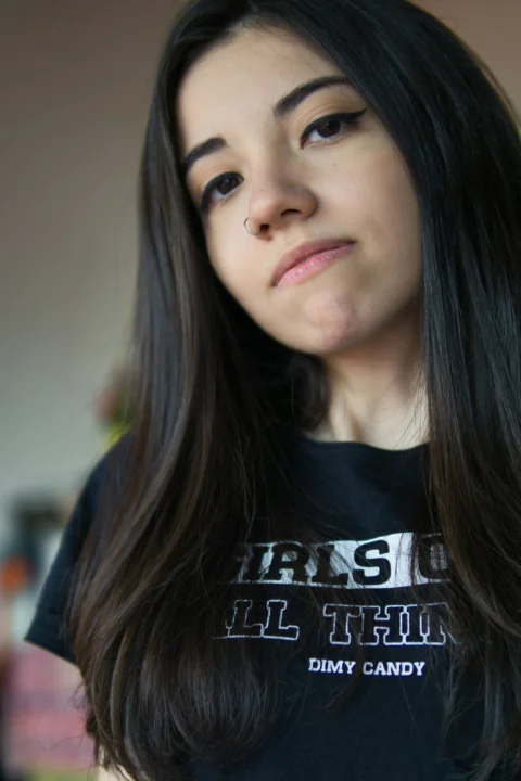 a woman with long black hair wearing a black shirt