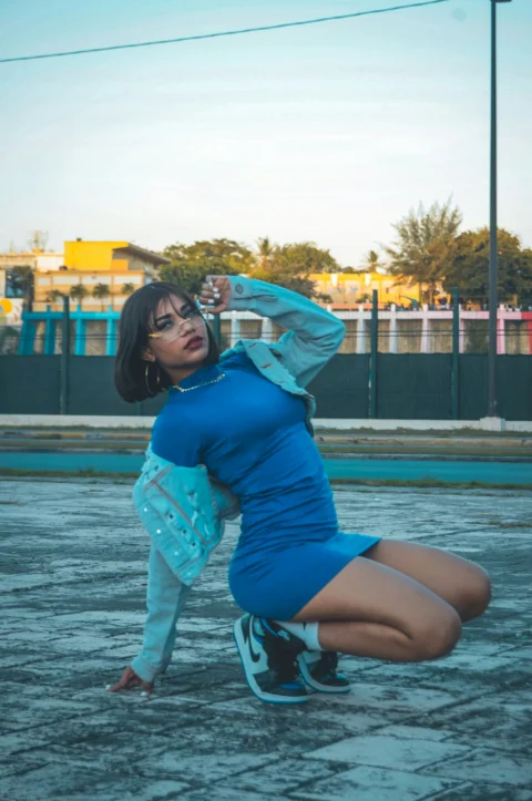 a woman in a blue dress kneeling on the ground