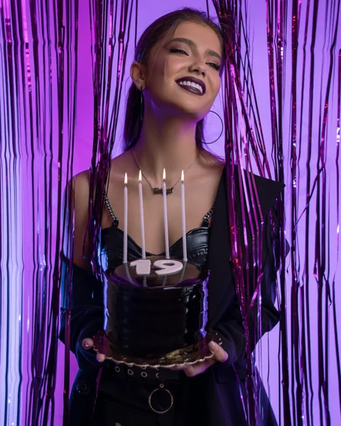a woman holding a cake with candles in it