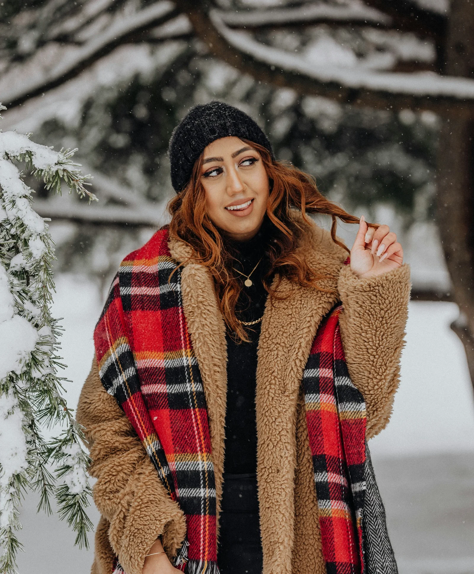 戴着格纹围巾站在雪地里的女子