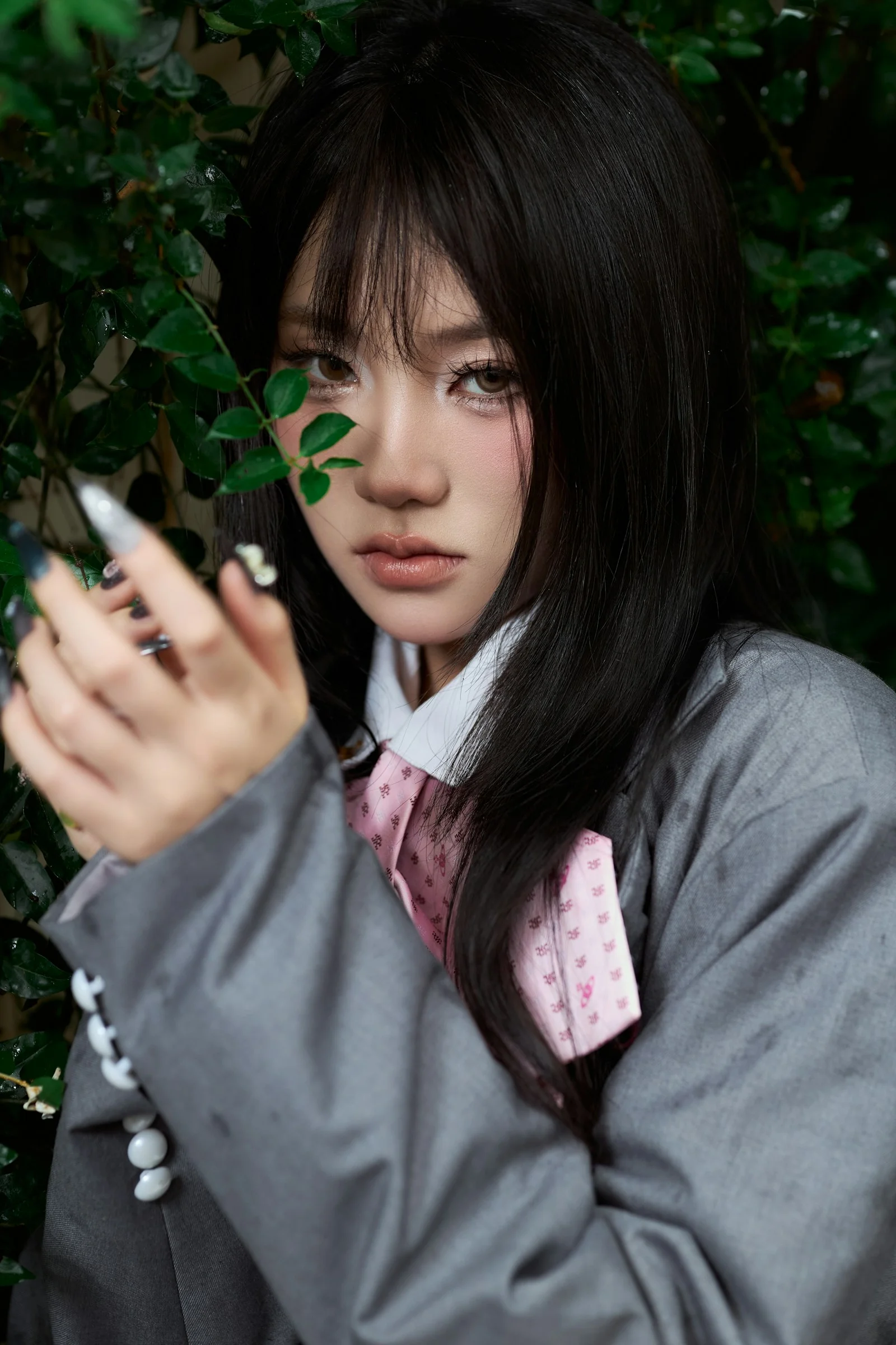 深色頭髮、繫著粉色領帶的年輕女子與綠葉