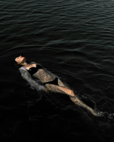 a person lying on a whale's back in the water