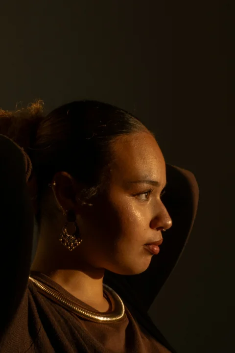 A woman is posed in dramatic lighting