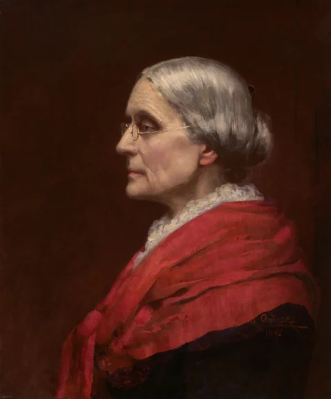 Older woman in profile wearing glasses and a red shawl