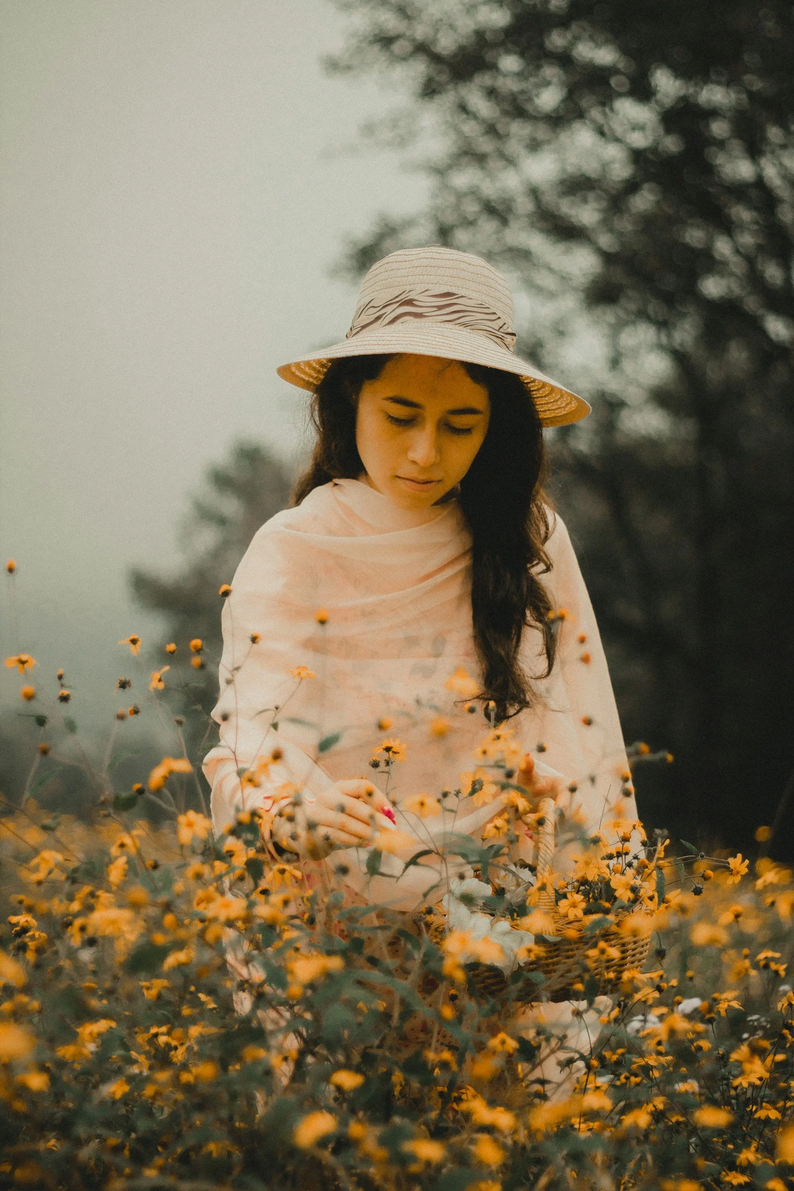 白天,身穿白棕花卉長袖襯衫的女性站在黃色花田中