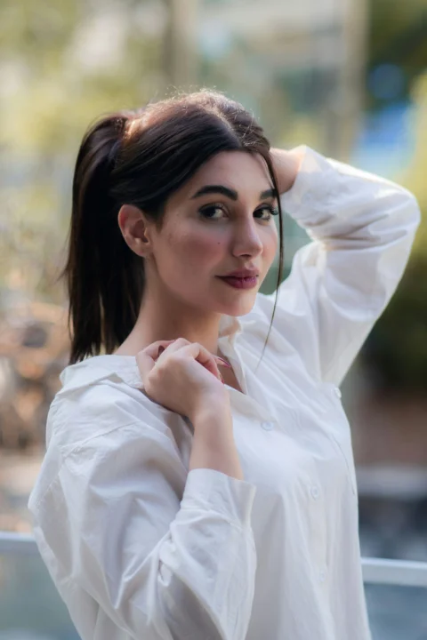 Young woman with dark hair in a white shirt