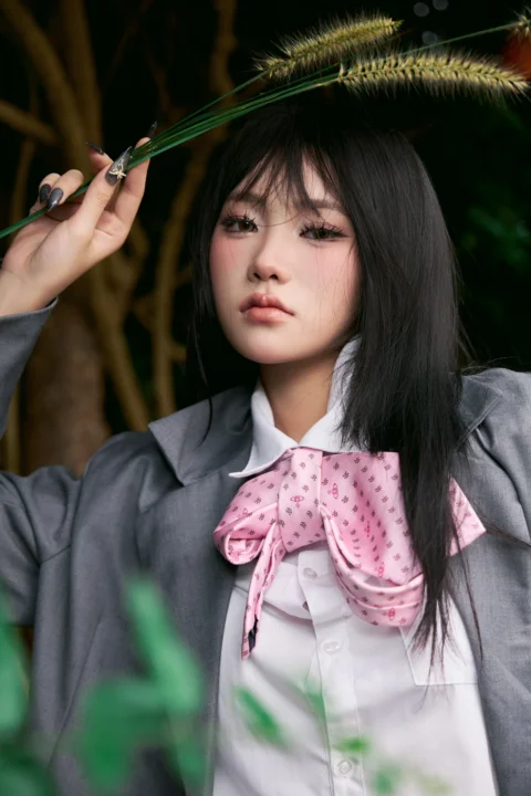 Stylish young woman in uniform holding a plant stem