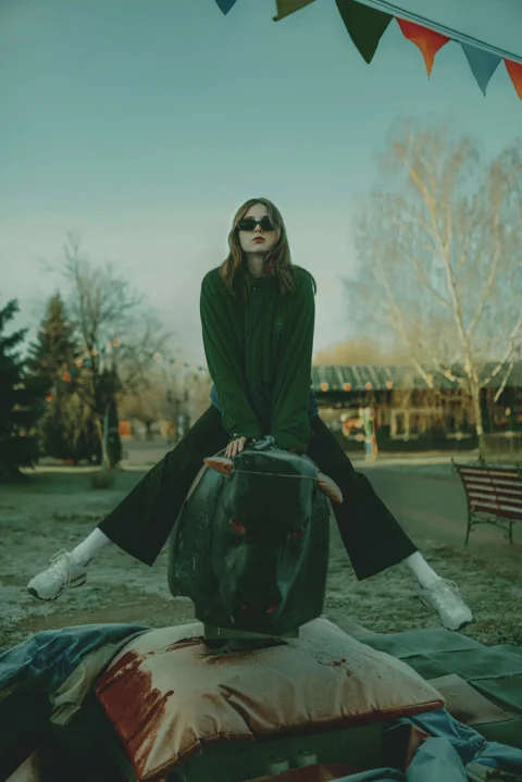 a woman sitting on top of a green object
